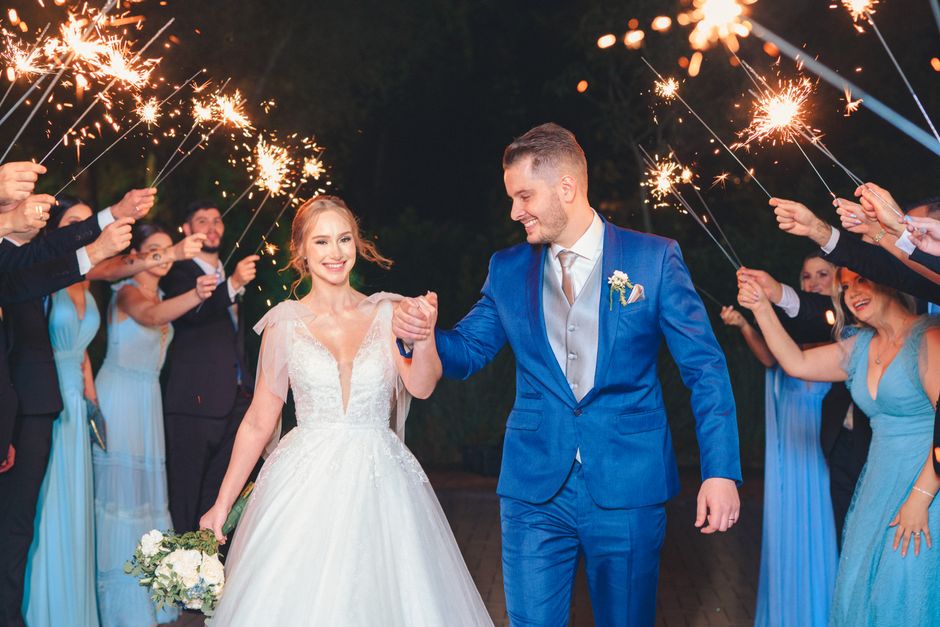 Joyful wedding sparkler send off at night